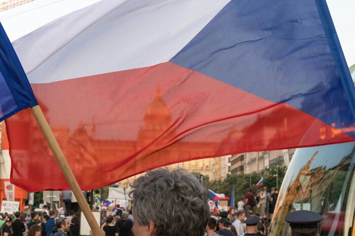 Crowd holding Czech Republic flag at a public event, illustrating European netizens correcting country misconceptions.