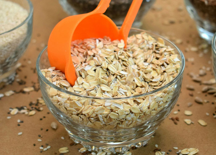 Glass bowl filled with oats and orange scoops, representing healthy foods some dentists and doctors suggest skipping.