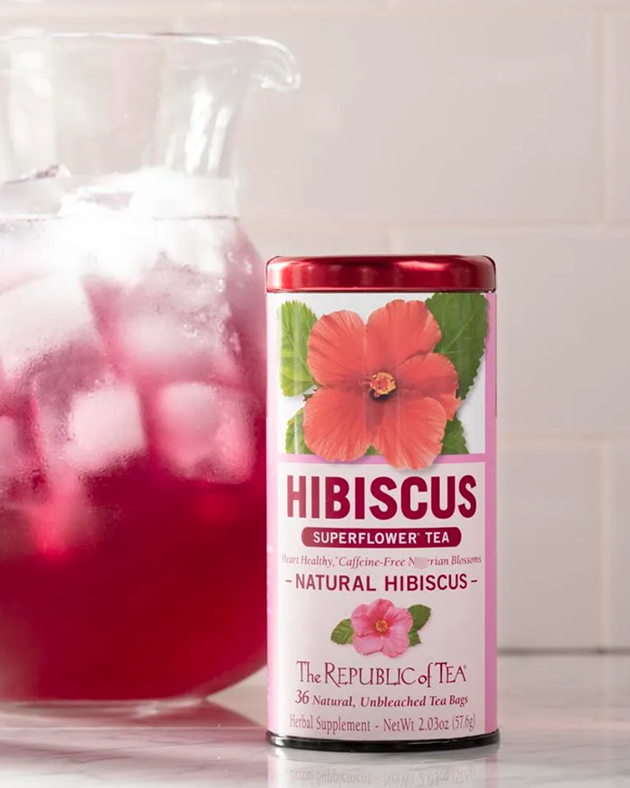 Hibiscus tea product from Meghan Markle's brand, placed next to a pitcher of iced hibiscus tea on a kitchen counter. Hibiscus tea product from Meghan Markle's brand, placed next to a pitcher of iced hibiscus tea on a kitchen counter.