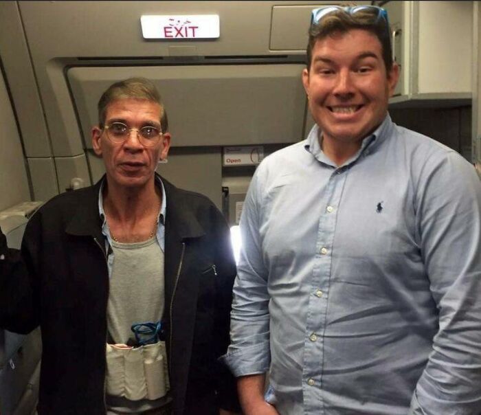 Two men on a plane, one wearing a fake explosive vest, illustrating men doing dumb things humorously.
