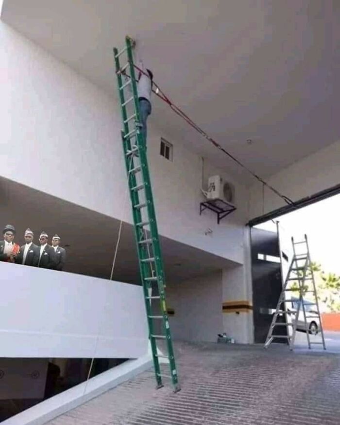 Man climbing a tall ladder using a precarious rope setup, illustrating risky behavior from men doing dumb things.