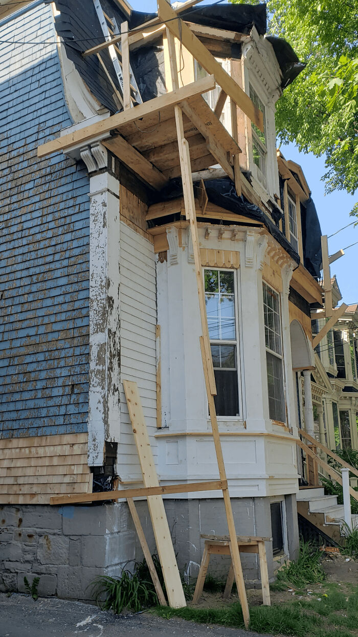 Old house under repair with poorly supported wooden scaffolding, illustrating men doing dumb things concept.
