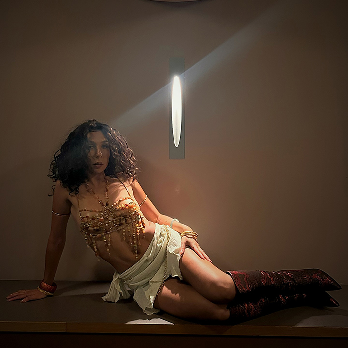 Aboriginal artist reclining in beads and boots, singing about breaking King Charles' neck, sparking debate at Buckingham Palace. Aboriginal artist reclining in beads and boots, singing about breaking King Charles' neck, sparking debate at Buckingham Palace.