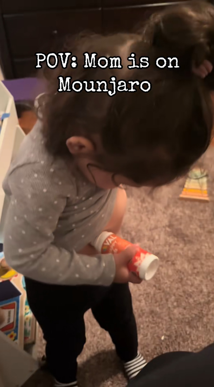 Toddler pretending to inject weight-loss medication while standing on carpet with text overlay about Mounjaro.