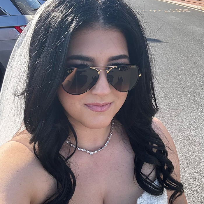 Woman with long dark hair wearing sunglasses and a necklace, outdoors on a sunny day, related to weight-loss med controversy.