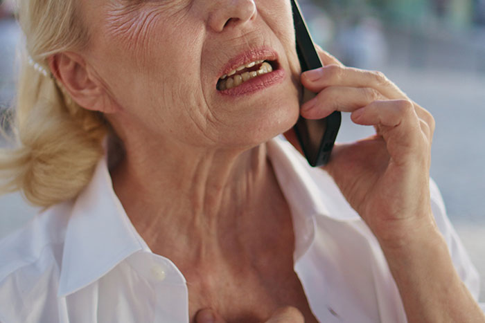 Angry older woman speaking on phone with distressed expression, seeking advice on how to handle CPS threat. Angry older woman speaking on phone with distressed expression, seeking advice on how to handle CPS threat.