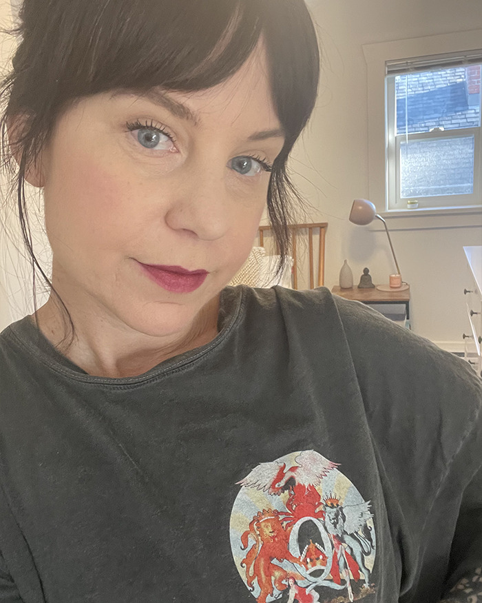 Single mom with early-onset Alzheimer's posing indoors with a thoughtful expression and casual dark shirt in a bright room.