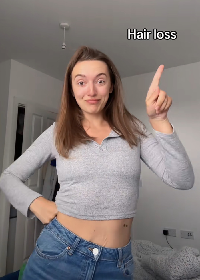 Woman pointing to text about hair loss, discussing side effects of Mounjaro after significant weight loss.