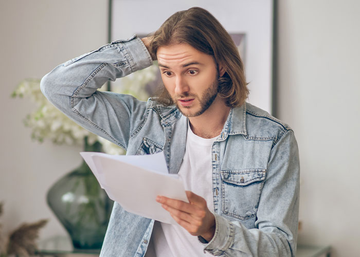 Man inherits house and looks shocked reading documents, tenant expresses fear about living conditions in the home.