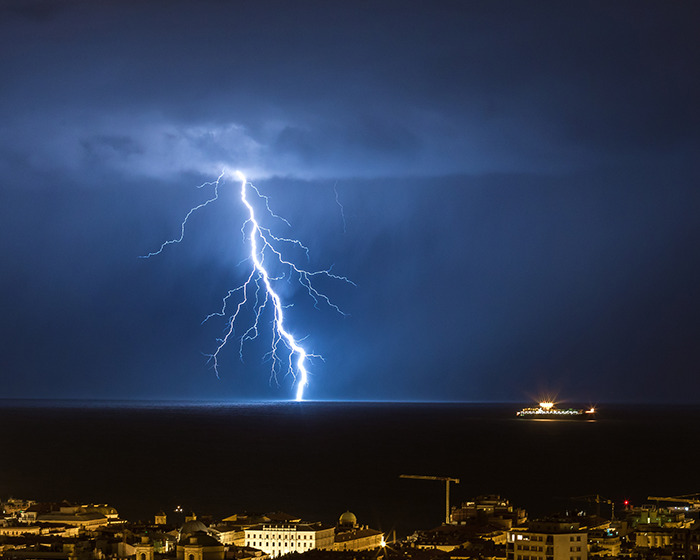 Lightning striking over water at night during storm, illustrating tragedy risk on newlywed&rsquo;s honeymoon near ankle-deep water.