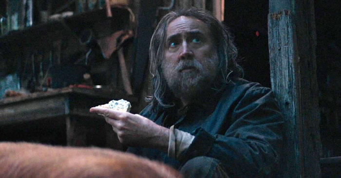 Nicolas Cage wearing a fat suit on set of a biopic about legendary football coach John Madden in a dimly lit scene. Nicolas Cage wearing a fat suit on set of a biopic about legendary football coach John Madden in a dimly lit scene.