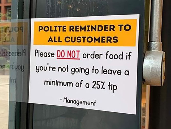 Sign at a restaurant demanding a minimum 25% tip, highlighting the ridiculous tipping culture in today’s service industry.