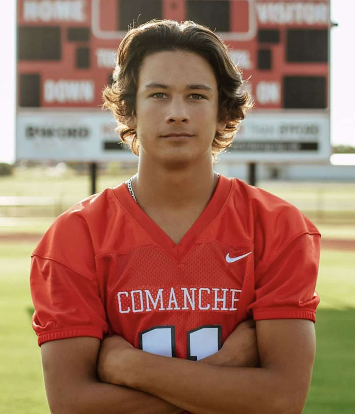 Teen in Comanche football jersey posing with arms crossed, related to family lawsuit after teen's undressed corpse found. Teen in Comanche football jersey posing with arms crossed, related to family lawsuit after teen's undressed corpse found.