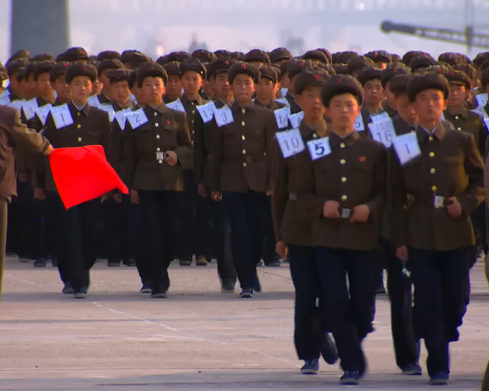 North Korean soldiers marching in formation, illustrating control measures linked to smuggled smartphone exposure.