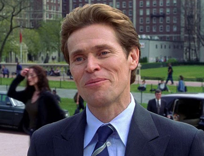 Man in a suit smiling outdoors with buildings and people in the background, illustrating absurd legal claims discussion.