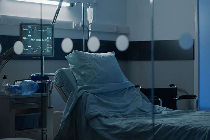 Empty hospital bed with medical equipment and heart monitor illustrating moments that changed healthcare workers forever.