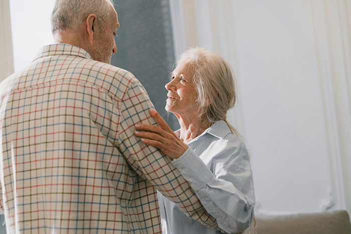 Elderly couple sharing a tender moment indoors, highlighting compassionate care and emotional connection in healthcare workers' experiences.