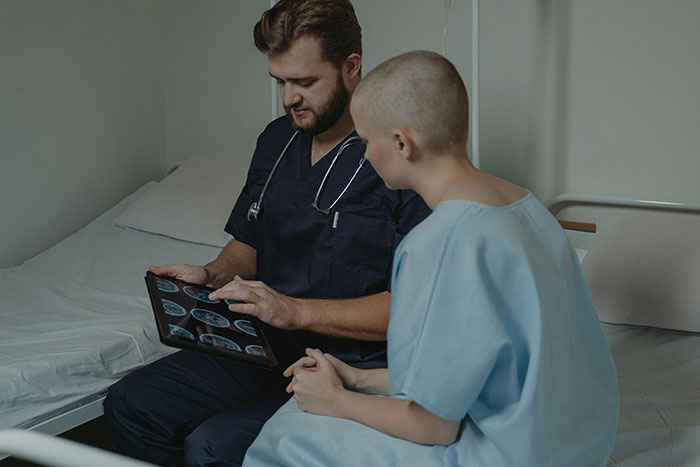 Healthcare worker discussing brain scans with a patient in a hospital room, highlighting impactful moments in healthcare.