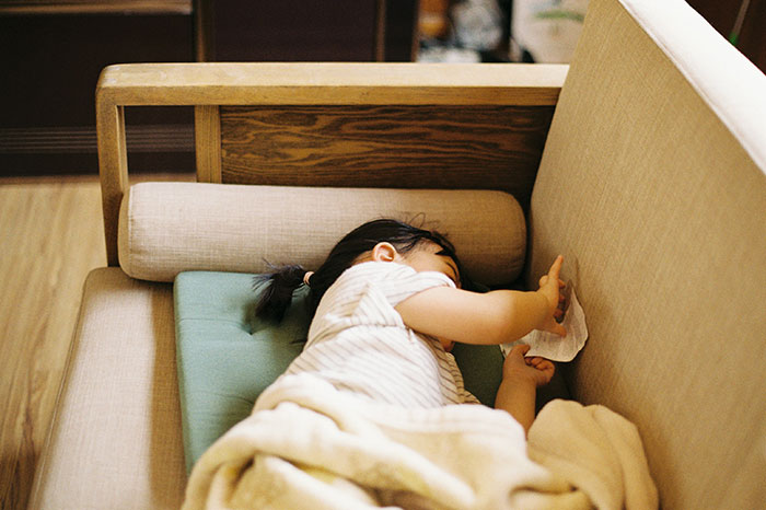 Young child resting on a beige couch with a blanket, illustrating moments that changed healthcare workers forever.