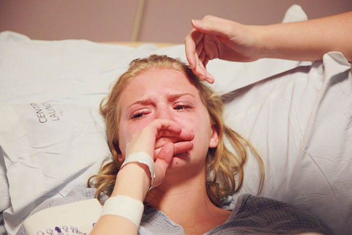 Young woman in hospital bed visibly upset, highlighting emotional moments that changed healthcare workers forever.