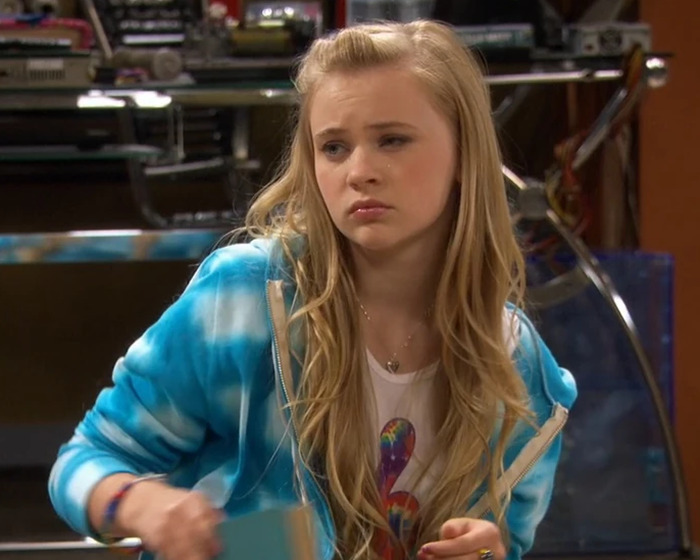 Teen girl wearing a blue hoodie looking pensive, illustrating child star's unrecognizable transformation and sinister Disney pattern concerns.