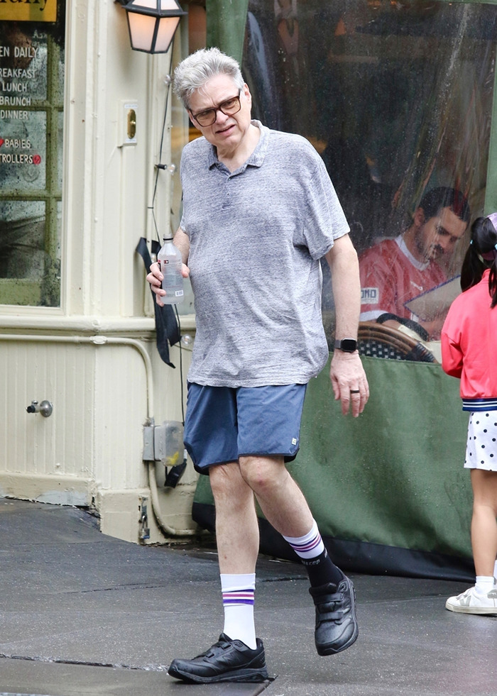 Super underrated 90s actor casually dressed in shorts and gray shirt walking outside a cafe holding a water bottle. Super underrated 90s actor casually dressed in shorts and gray shirt walking outside a cafe holding a water bottle.