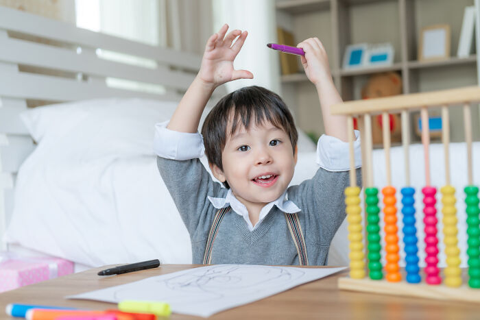 Young child counting colorful beads on an abacus, engaged in learning with one Mississippi counting countries concept.