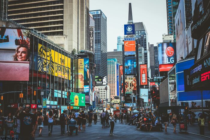Crowded urban street view with numerous advertisements and billboards showcasing vibrant city life and one Mississippi counting countries theme.