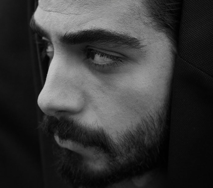 Close-up of a man with a beard looking pensive, representing parents who disowned their children and their difficult choice.