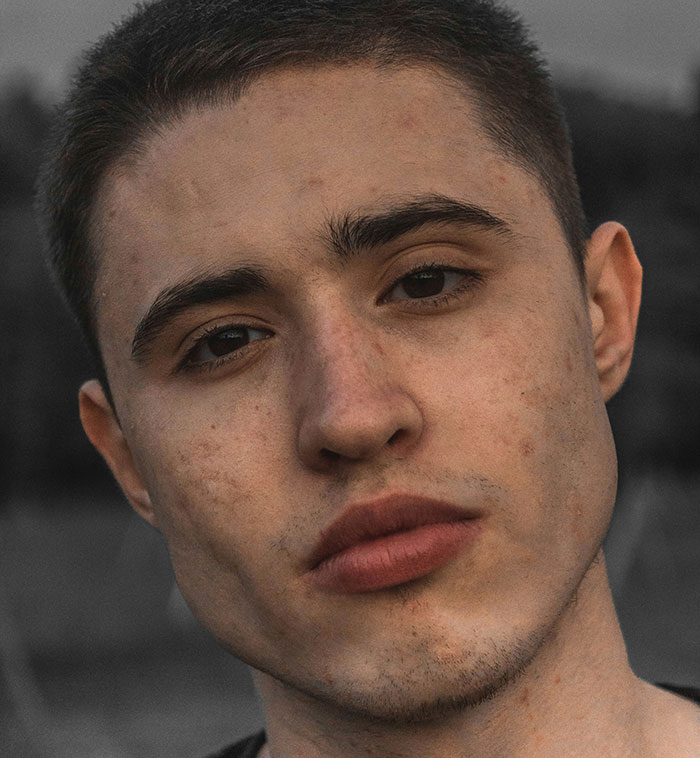 Close-up of a young man with a serious expression, representing parents who disowned their children decisions.