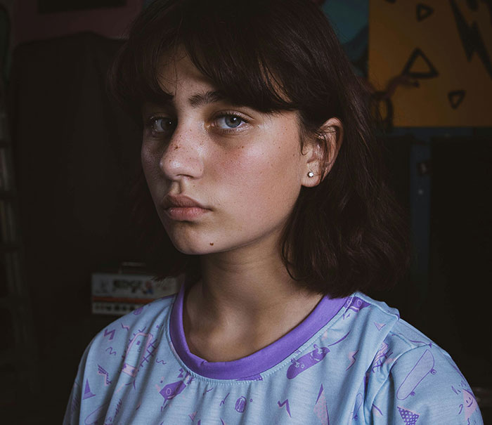 Teenage girl with a serious expression, symbolizing parents who disowned their children and the reasons behind it.