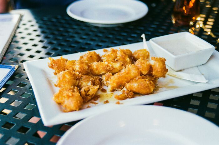 Plate of golden fried food on a table illustrating Americans reveal things non-Americans do like breaking spaghetti