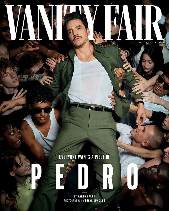 Pedro Pascal posing confidently in a green suit surrounded by people reaching toward him for Vanity Fair cover.