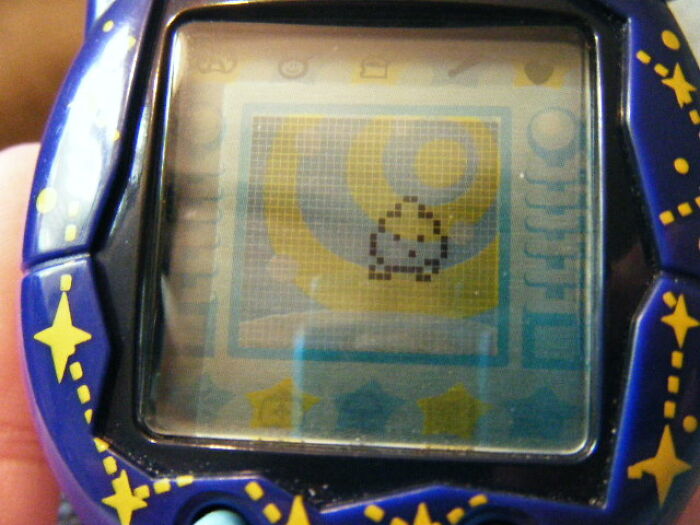 Close-up of a handheld digital pet device representing skills people online needed before the 2000s but don't need now.