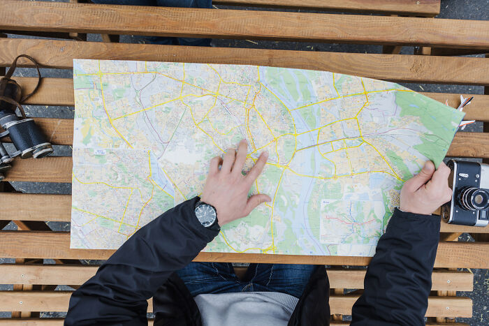Person using map for navigation, illustrating skills people online needed before the 2000s but don't need anymore.
