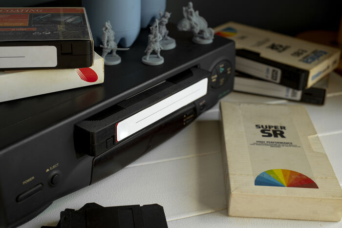 Vintage VCR with video tapes and retro gaming miniatures, highlighting skills people online needed before the 2000s.