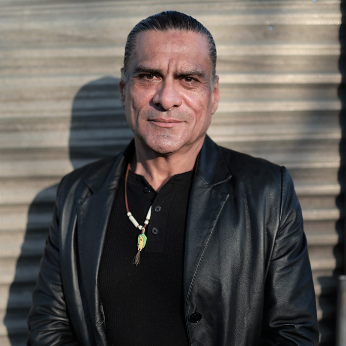 Man wearing a black leather jacket and necklace standing outdoors, related to Chris Pratt sparks heated reactions topic.