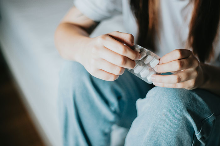 Person holding medication pills, symbolizing experiences of psychosis and the challenges faced during terrifying episodes.