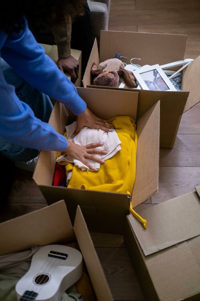 Person packing belongings into boxes while sorting through items after a loved one’s death finding disturbing things