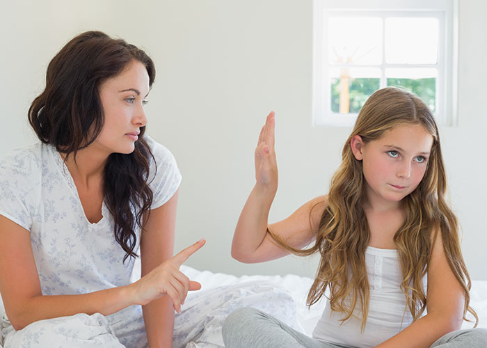 Woman and girl having a serious conversation in bright room, reflecting on darkest secrets shared anonymously.