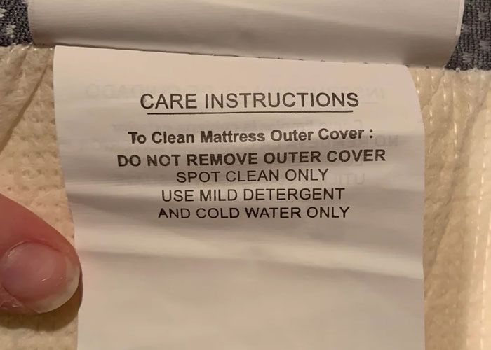 Care instructions label on mattress outer cover advising spot clean with mild detergent and cold water only.