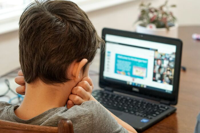 Child sitting at a desk using a laptop, experiencing a scary online moment that left them traumatized.
