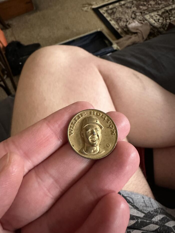 Person holding a small vintage collectible token found in walls or other places that really confused them.