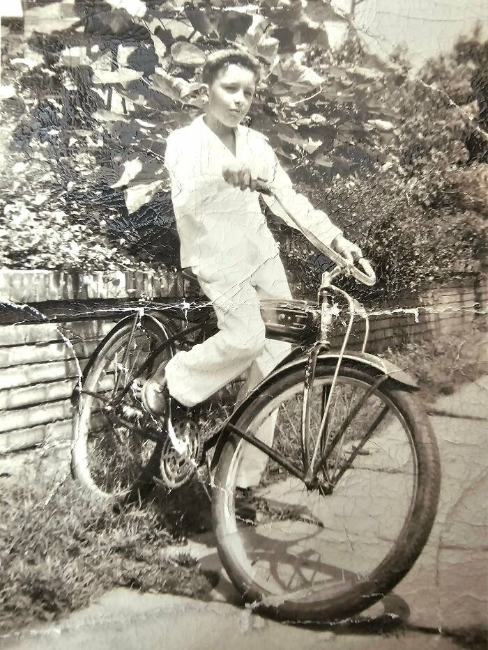 Black and white vintage photo of a boy on a bicycle, illustrating people found in their walls or other places.