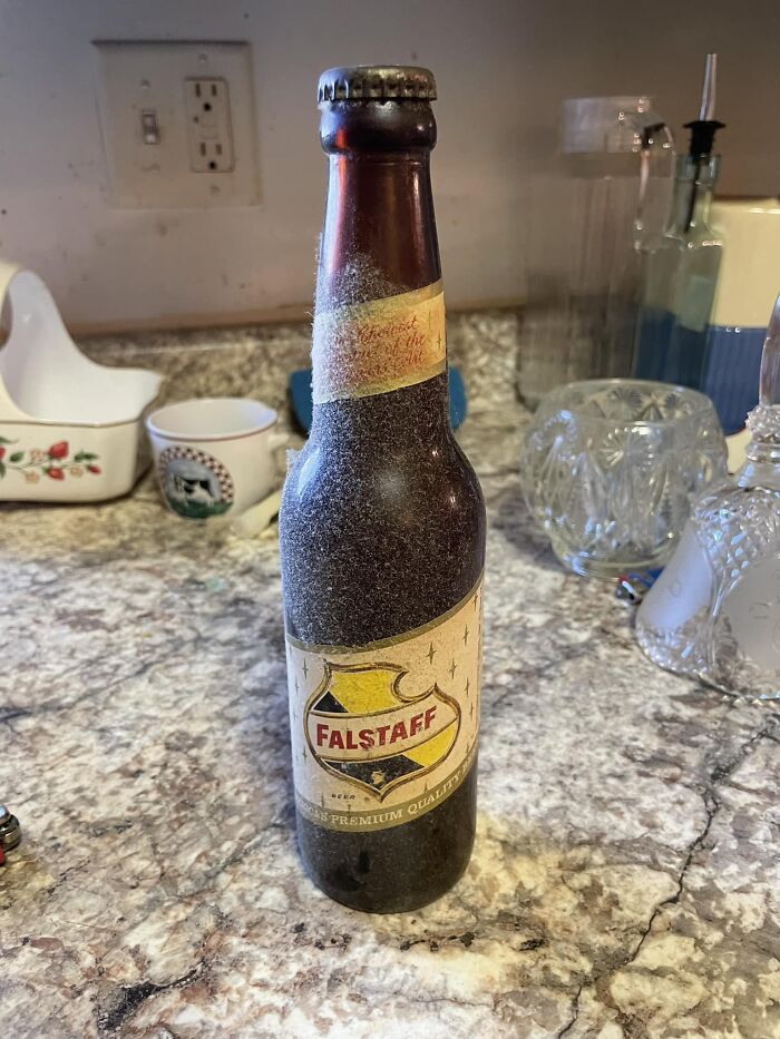 Old dusty Falstaff beer bottle found in unexpected places, one of the confusing things people discovered in walls or other spots.