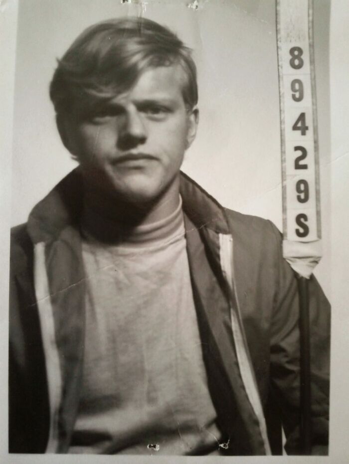 Black and white vintage mugshot photo of a young man, an example of things people found in their walls that confused them.