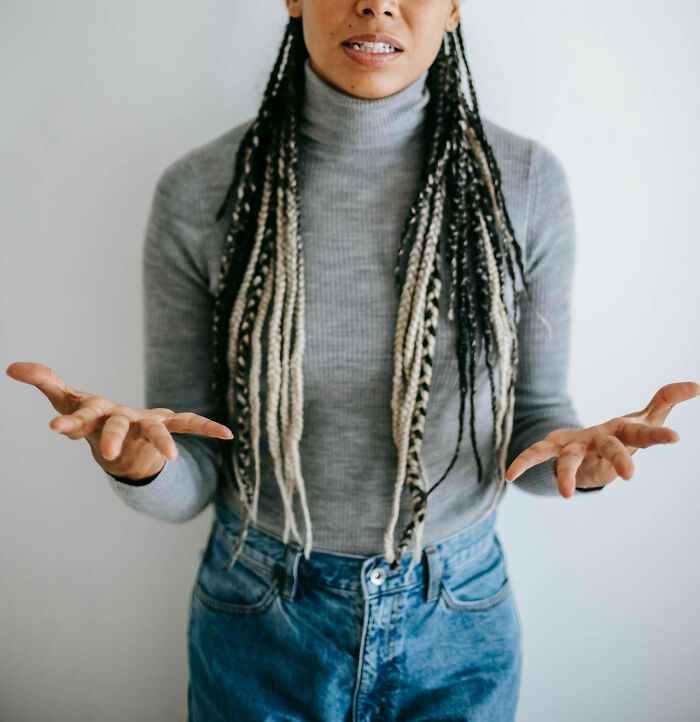 Woman with long braided hair in a gray turtleneck and jeans expressing frustration about worst parents seen