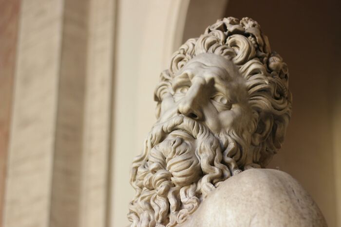Marble statue with detailed curly beard and hair in a classical European setting, symbolizing European netizens' cultural insights.