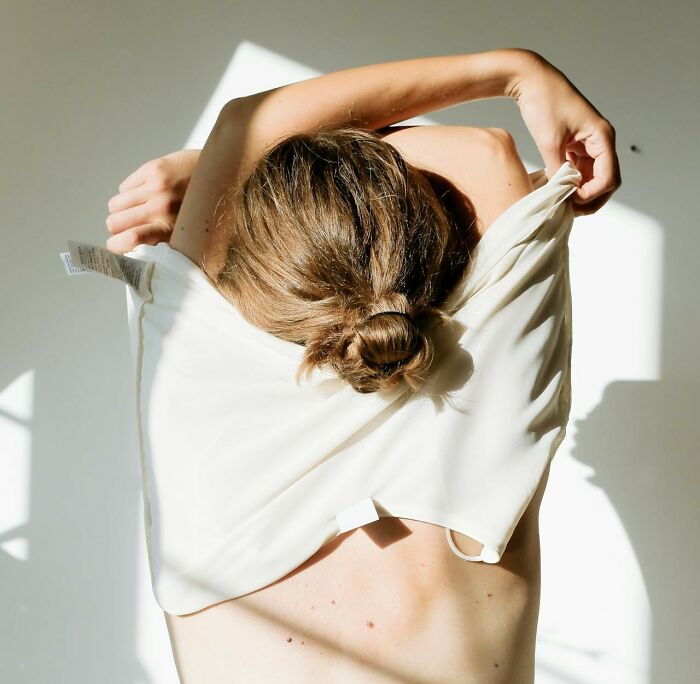 Person removing a shirt in bright light, illustrating weird things couples started doing that are hard to explain.