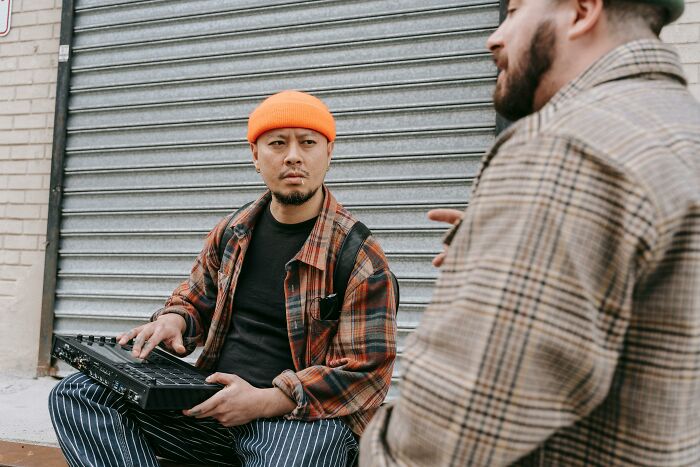 Two men in casual wear talking outdoors, illustrating casual and harmless looking habits that may be damaging in the long run.